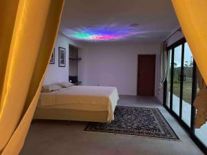1 dormitorio con cama y techo colorido en Sitio Lipa - Villa da Mata en São Miguel Arcanjo