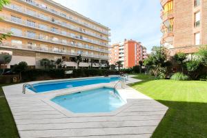 a swimming pool in a yard next to a building at Apartamento Disa in Lloret de Mar