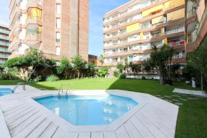 a swimming pool in front of a large building at Apartamento Disa in Lloret de Mar