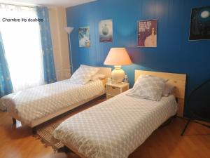 two beds in a room with blue walls at LE CERISIER in Sivry-Courtry