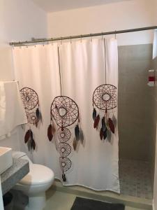 a bathroom with a shower curtain and a toilet at Casa Linda - Habitacion Puerto Morelos-Cancun-Playa Del Carmen in Puerto Morelos