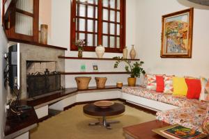 a living room with a couch and a fireplace at Pousada O Garimpo. in Embu