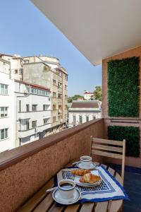 une table avec deux assiettes de nourriture sur un balcon dans l'établissement HOLT - Dolce in Napoli, à Bucarest