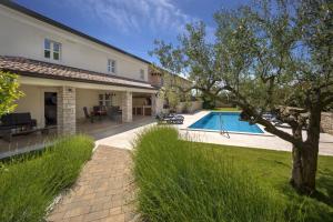 a backyard with a swimming pool and a house at Rustic villa Lori with whirpool and grill near Por in Nova Vas