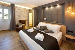 a bedroom with a large bed with two towels on it at Rustic villa Lori with whirpool and grill near Por in Nova Vas +13 photos