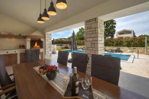 a dining room with a table and a fireplace at Rustic villa Lori with whirpool and grill near Por in Nova Vas