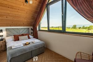 a bedroom with a bed in a room with windows at Białka i Skałka domki z balia i widokiem na góry in Białka Tatrzańska