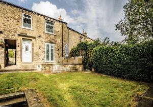 a brick house with a yard in front of it at The Cosy Tucked-Away Cottage in Huddersfield