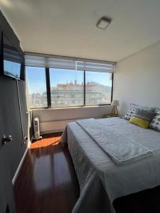 1 dormitorio con cama grande y ventana grande en Departamento en Providencia, en Santiago