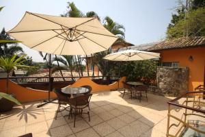 a patio with tables and chairs and umbrellas at Pousada O Garimpo. in Embu