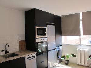 a kitchen with a stainless steel refrigerator and a microwave at Apartamento grande en Huesca in Huesca