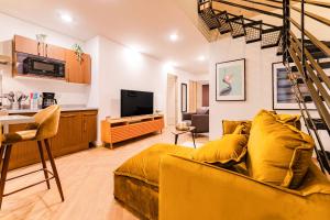 a living room with a yellow couch and a tv at Trendy La Roma Condo with Parking & Patio in Mexico City
