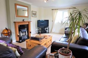a living room with a couch and a table and a tv at Large modern house in small rural Hamlet. in Duddon