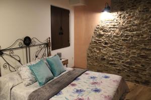 Un dormitorio con una cama y una pared de piedra. en Casa Rural El Mayadero, en Zamora