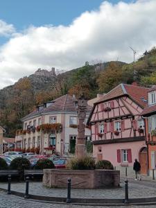 un gruppo di edifici e una statua in una città di Le Bretzel a Ribeauvillé