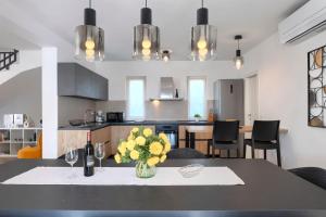 a kitchen with a table with a vase of flowers on it at Modern villa Oliveti with pool and grill in Porec in Frata