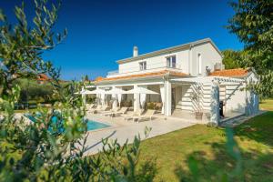 a villa with a swimming pool and a house at Modern villa Oliveti with pool and grill in Porec in Frata