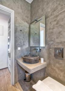 a bathroom with a stone sink and a mirror at Cape Mykonos in Mýkonos City