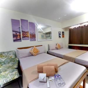Habitación con 2 camas y sofá en Affordable Ayala Avida IT Park Condo across Ayala Mall Central Bloc Sugbu Mercado, en Tabok