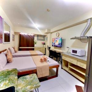 Habitación de hotel con 2 camas y escritorio con ordenador en Affordable Ayala Avida IT Park Condo across Ayala Mall Central Bloc Sugbu Mercado en Tabok