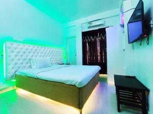 a bedroom with a bed and a television in it at White Rose Suites Ltd in Dhaka