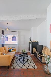 salon z kanapą i telewizorem w obiekcie Numéro 6 - Place Nationale - Wifi et Fibre w mieście Montauban