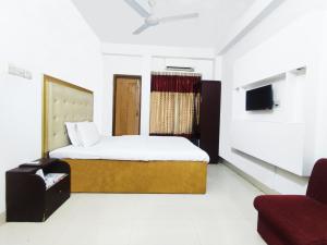 1 dormitorio con 1 cama y 1 silla en una habitación en White Rose Suites Ltd, en Dhaka