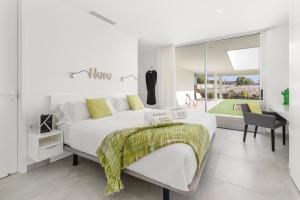 una camera da letto bianca con un letto grande e una scrivania di Karat Villa Zambrano a Guía de Isora Altre 32 foto