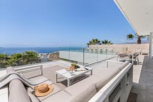 a patio with a couch and a table on a balcony at Karat Villa Zambrano in Guía de Isora