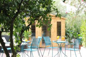 une terrasse avec des chaises et une table ainsi qu'une cabane pour chiens dans l'établissement Giardini Penelope, à Ciampino