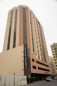 a tall building with a car parked in front of it at Juffair Trends Luxury Apartment in Juffair