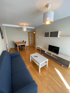een woonkamer met een blauwe bank en een tafel bij dp Calvo Sotelo 164, 4C in Sarria
