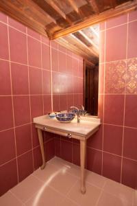 baño con lavabo y paredes de azulejos rojos. en Arasta Konak Boutique Hotel en Eskisehir
