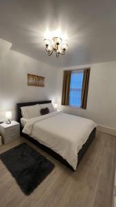 um quarto com uma cama grande e um lustre em New look flat In Waterloo em Londres