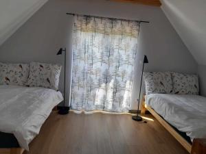 a bedroom with two beds in front of a window at Przystanek Las in Gąsawa