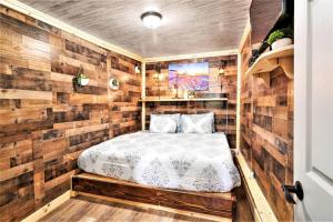 1 dormitorio con 1 cama en una habitación con paredes de madera en Dog Friendly Private Cabin w Hot Tub Leadville-A, en Leadville