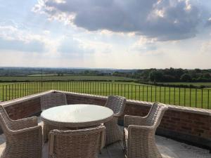 a table and chairs on a patio with a view at 2 Bedroom cottage with Beautiful views over the Mendips in Radstock