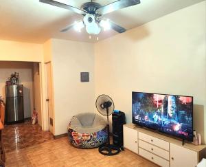a living room with a ceiling fan and a flat screen tv at Joi's Entire House @ Lessandra Gran Europa Lumbia in Cagayan de Oro