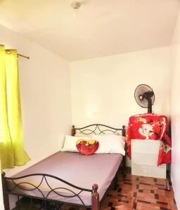a small bedroom with a bed and a suitcase at Joi's Entire House @ Lessandra Gran Europa Lumbia in Cagayan de Oro