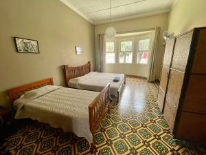 um quarto com 2 camas e uma janela em Costa Rica Guesthouse em San José