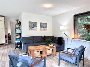 sala de estar con sofá, sillas y mesa en Vakantiehuis Bos en Hei Veluwe en Epe