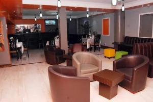 un ristorante con sedie, tavoli e pianoforte di Leawood Hotel a Lekki