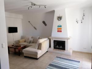 a living room with a couch and a fireplace at Casa do Quebrado in Peniche