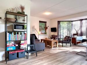 a living room with a book shelf filled with books at Vakantiehuis Bos en Hei Veluwe in Epe