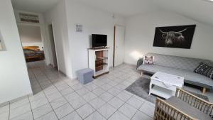 ein Wohnzimmer mit einem Sofa und einem TV in der Unterkunft Ferienwohnung Sengbach in Solingen