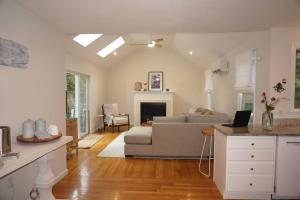 a kitchen and living room with a couch and a fireplace at Wedgewood Cottage in Barnstable