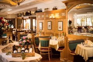 um restaurante com duas mesas e toalhas de mesa brancas em Vital - und Wellnesshotel Hanneshof em Filzmoos