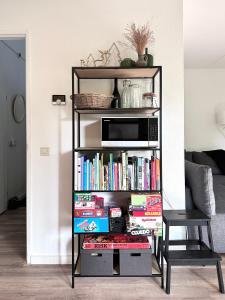 a book shelf filled with books and a microwave at Vakantiehuis Bos en Hei Veluwe in Epe