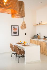 a kitchen with a white table and chairs at Vila Ser tão zen in Tibau do Sul