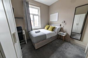 Dormitorio pequeño con cama y espejo en NEWLY REFURBISHED House - FREE Wi-Fi!, en Wyken
